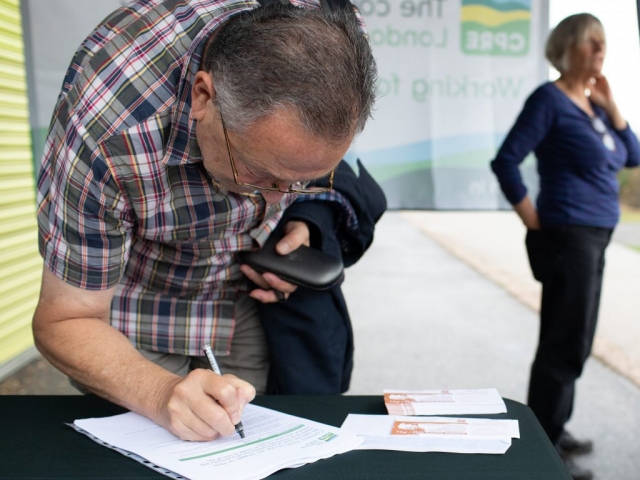 Man in checked shirt signing in at litter pick