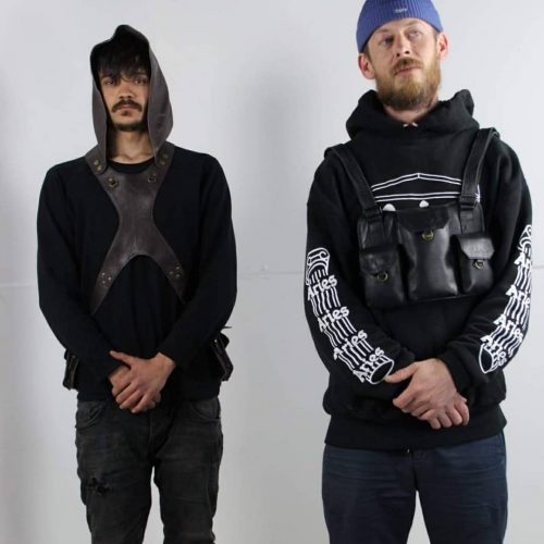 leather bag and leather hood worn by two men in black clothing